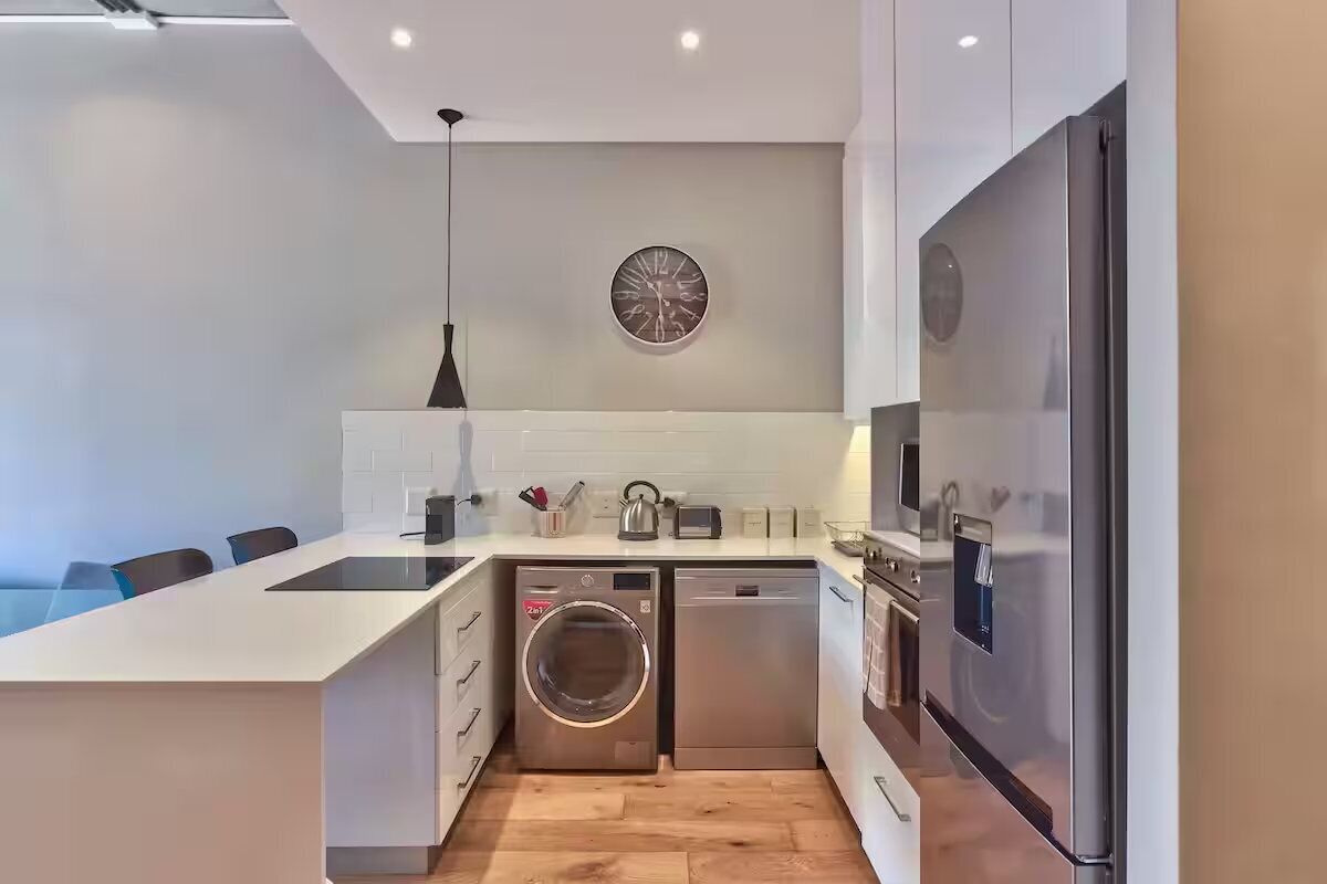 A modern kitchen with a built-in dishwasher, oven, and refrigerator.