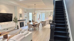 Un salon moderne avec un canapé, un téléviseur et un coin repas.