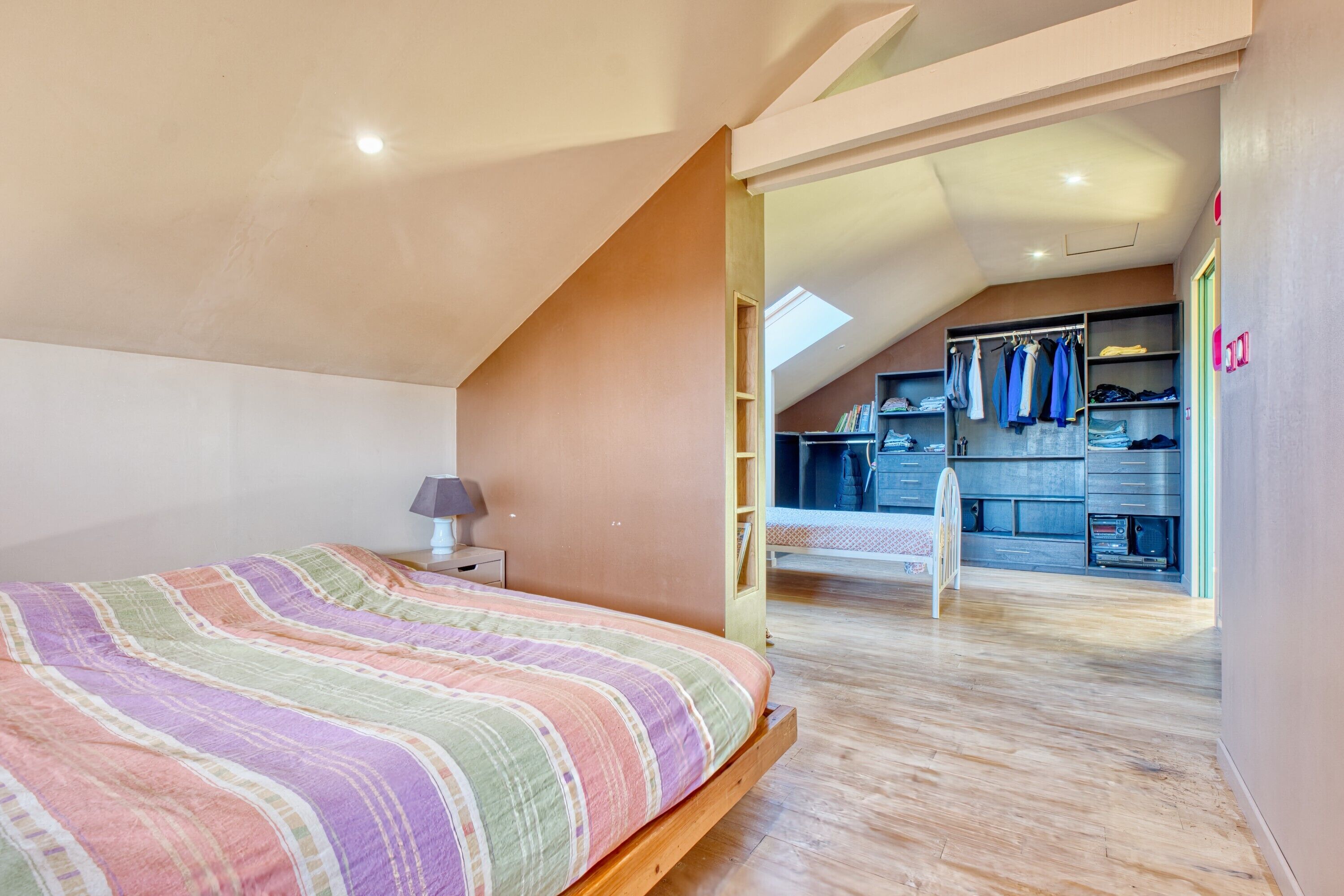 Una camera da letto con un letto, un comodino, una scrivania e una cabina armadio.