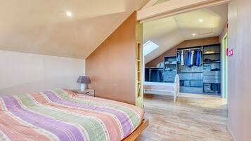 Una camera da letto con un letto, un comodino, una scrivania e una cabina armadio.