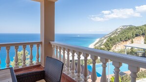 Ein Balkon mit Blick auf das Meer und ein Berg.