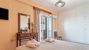 Ein Schlafzimmer mit einem Bett, einem Schminktisch, einem Spiegel, einem Stuhl und einem Kleiderschrank.
