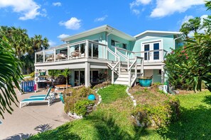 Une maison à deux étages avec un balcon, une piscine et un jardin.