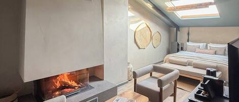 A modern loft bedroom with a fireplace, a bed, a sofa, and a coffee table.