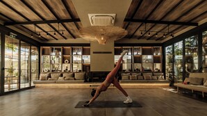 Ett rymligt rum med ett stort fönster, en takfläkt och en yogamatta på golvet.