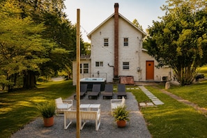 A house with a hot tub, outdoor seating, and a gravel patio.