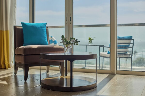 A modern room with a brown leather sofa, a glass coffee table, and a view of the sea through large windows. - MCollection - Stay Near Private Beach in Boracay (Boracay Island)