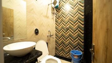 A bathroom with a white sink, a toilet, and a shower.