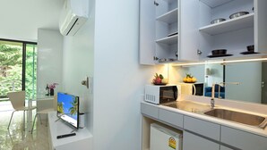 A modern kitchen with white cabinetry, a built-in microwave, and a stainless steel sink. - Kata Pool Villa UTK5 for Beach Lovers  (Karon)
