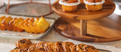 A buffet with various baked goods, including muffins and cookies.
