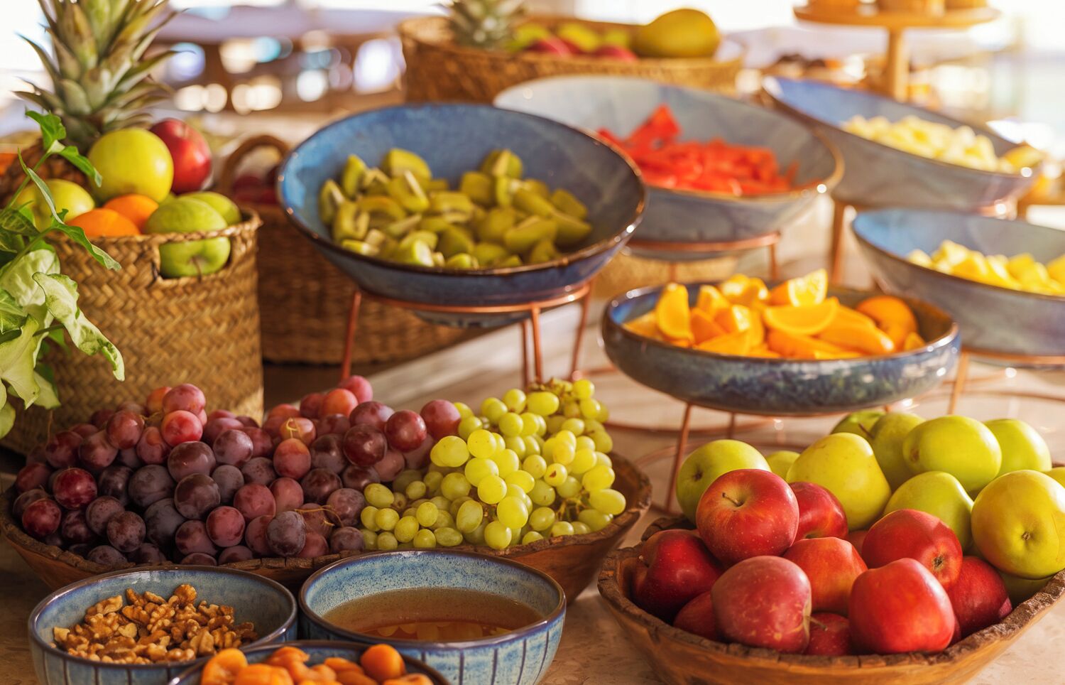 A variety of fruits and nuts displayed in bowls and baskets.