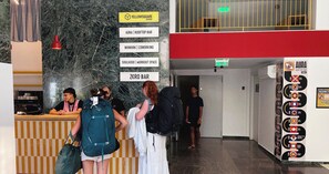 A hotel lobby with a reception desk, a sign for 'AURA | ROOFTOP BAR', and a directory for 'YELLOWSQUARE ATHENS'. - YellowSquare Athens (Athens)