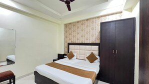 Ein Hotelzimmer mit Bett, Schrank, Spiegel und Deckenventilator.