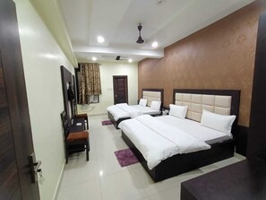 A hotel room with a large bed, a desk, and a chair. - Heritage Villa (Kichha)