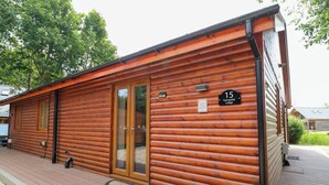 Il s’agit d’un bâtiment de style chalet en rondins, avec une façade en bois, une porte d’entrée en verre et une enseigne indiquant qu’il s’agit du « Sunnyside Lodge », numéro 15.