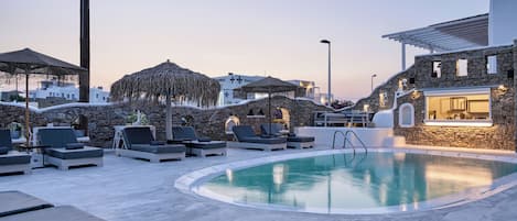 Een buitenzwembad, parasols voor strand/zwembad