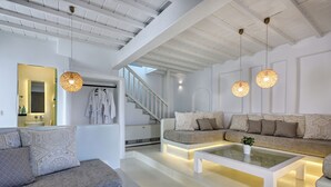Una sala moderna con un sofá, una mesa de centro y lámparas colgantes.