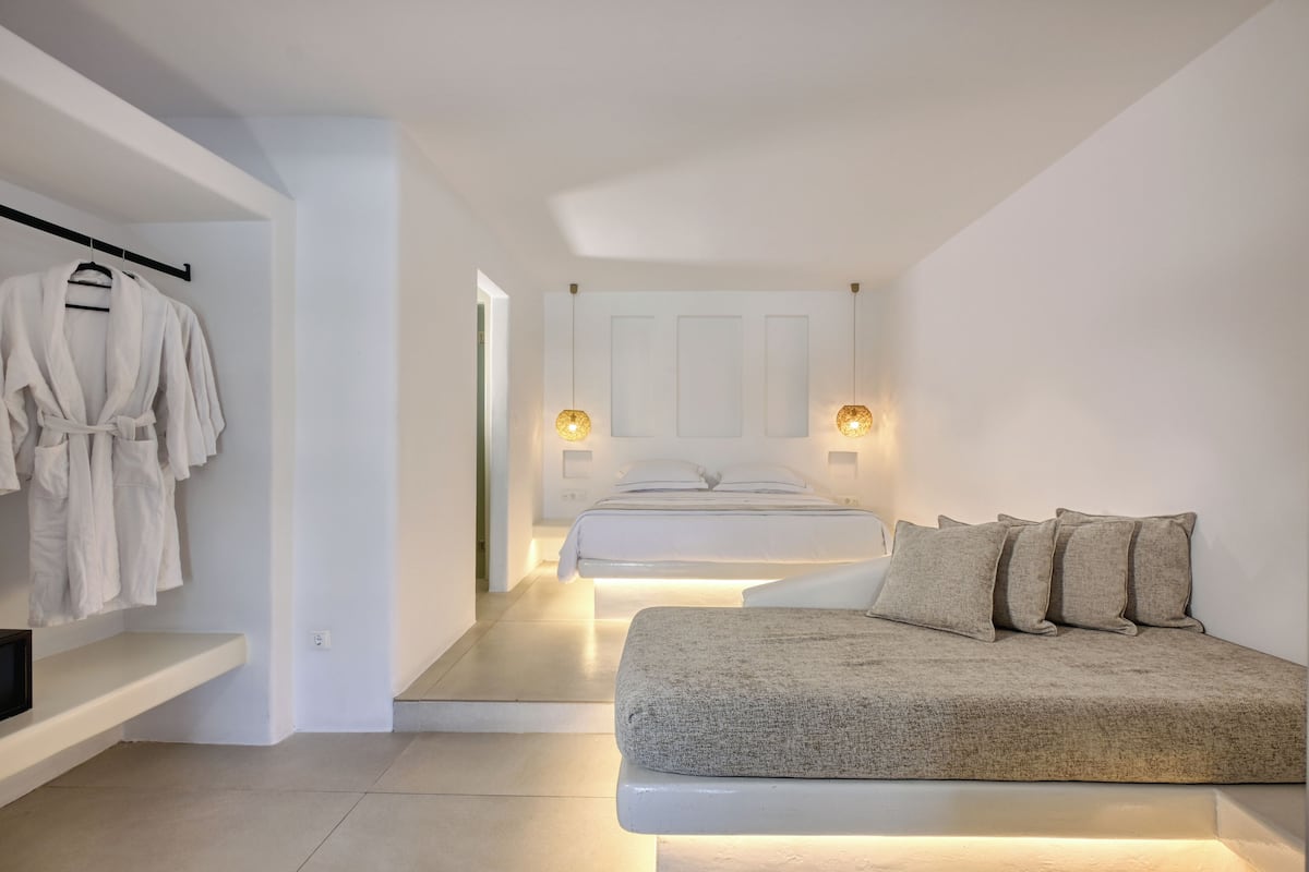 Une chambre à coucher moderne avec un lit, des tables de chevet et un porte-manteau.