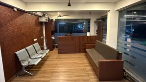A modern interior with a reception desk, seating area, and a view through a large window. - Indeo Residency (Kanayannur)