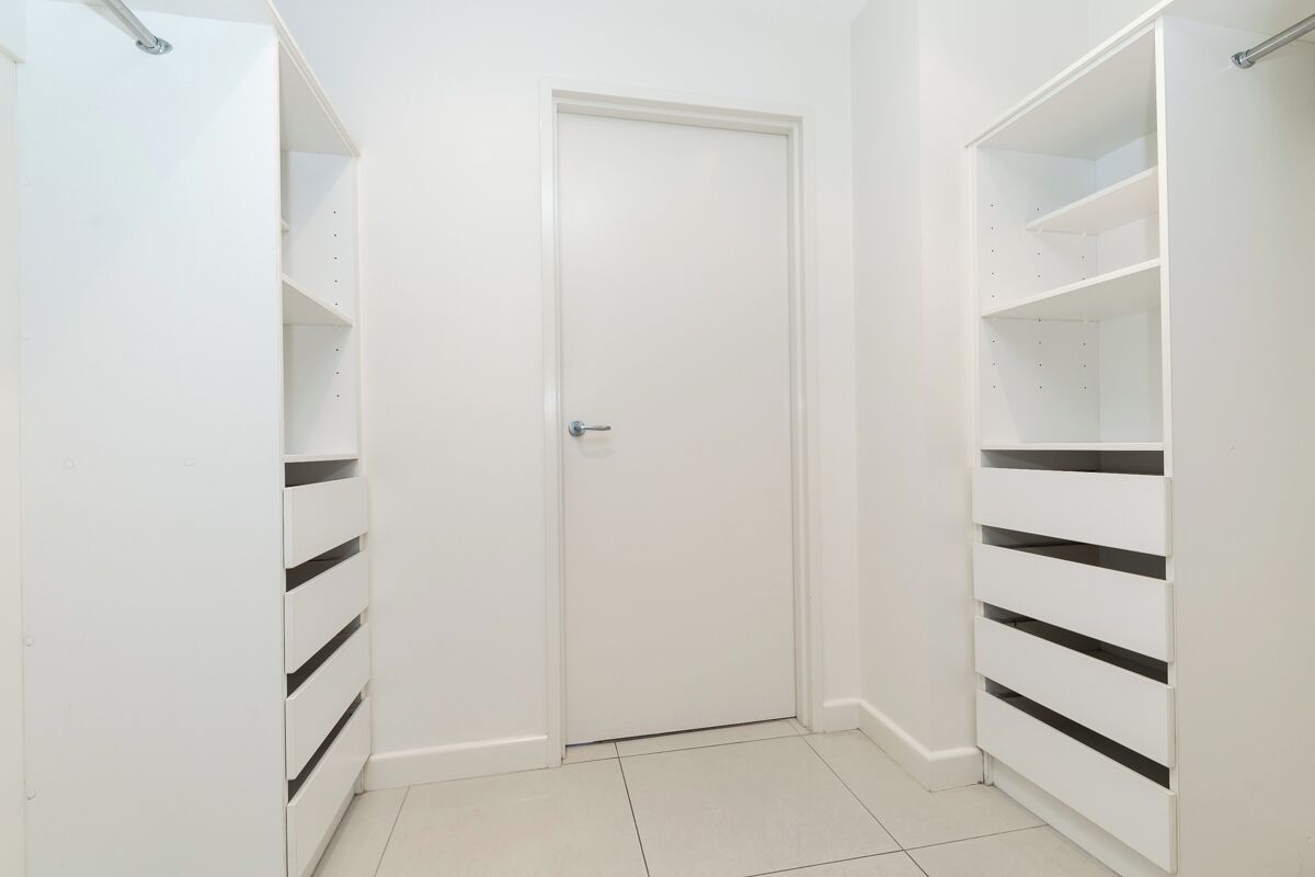 A white closet with sliding doors and shelves.