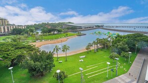 Un hôtel doté d’une grande piscine, de palmiers et offrant une vue sur l’eau.