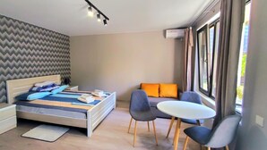 Une chambre à coucher moderne avec un lit, des tables de chevet, un bureau et des chaises.