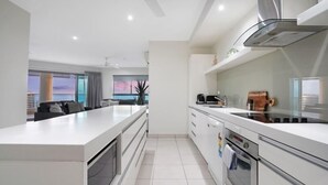 A modern kitchen with a large island, stainless steel appliances, and a view of the city.