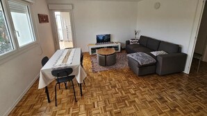 Un espacio habitable compacto con una mesa de comedor, sofá y televisor.