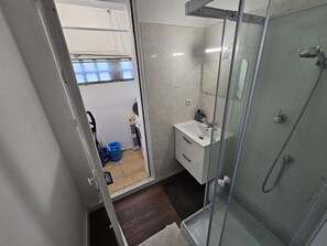 Chuveiro, toalhas de banho, sabonete, papel higiênico