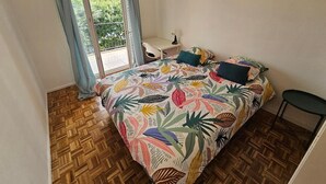Un dormitorio con cama, escritorio y silla.