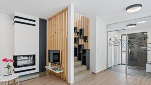 A modern interior with a wooden partition, a flat-screen TV, and a glass door with a map. - Lovely apartment for 4 people with WIFI, TV and terrace (Železný Brod)