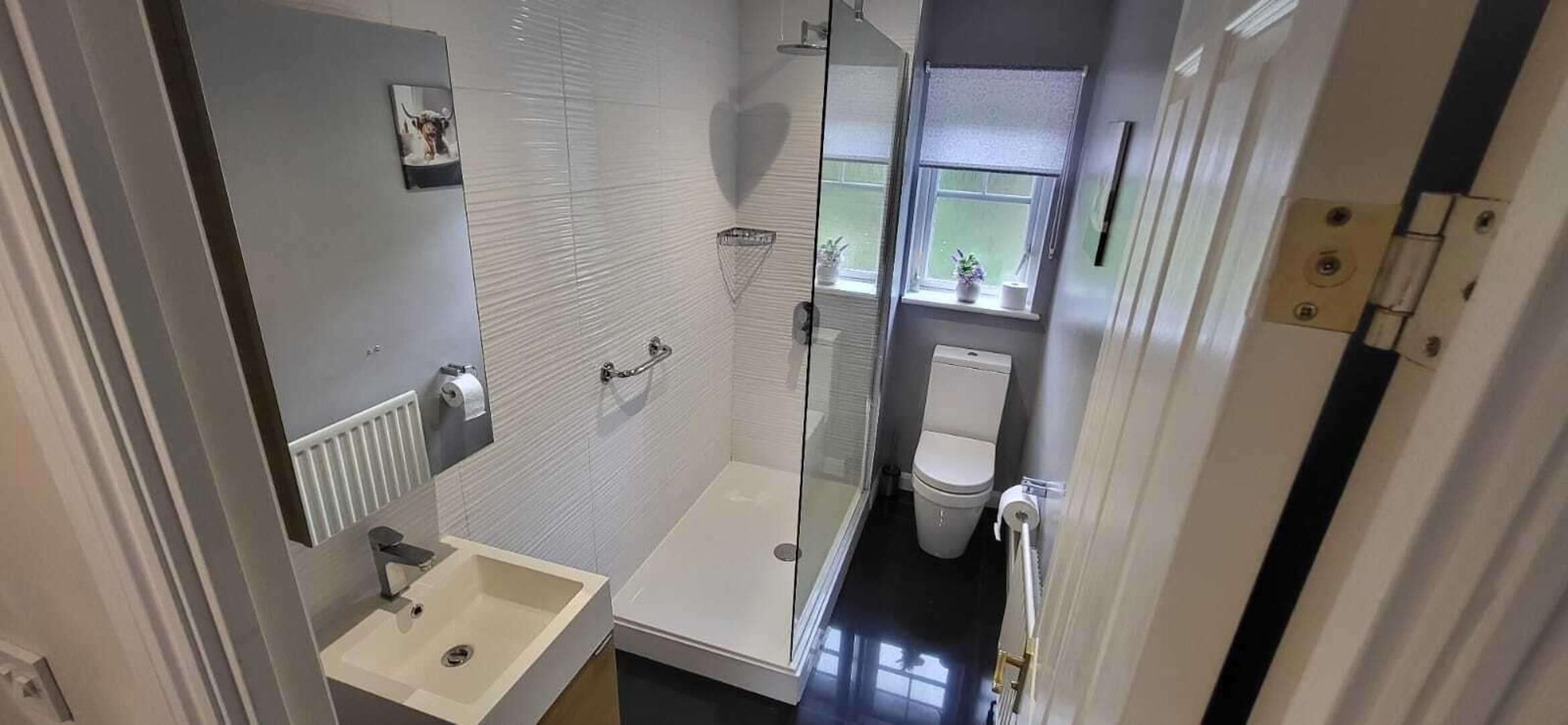 A compact bathroom with a shower, toilet, and sink.