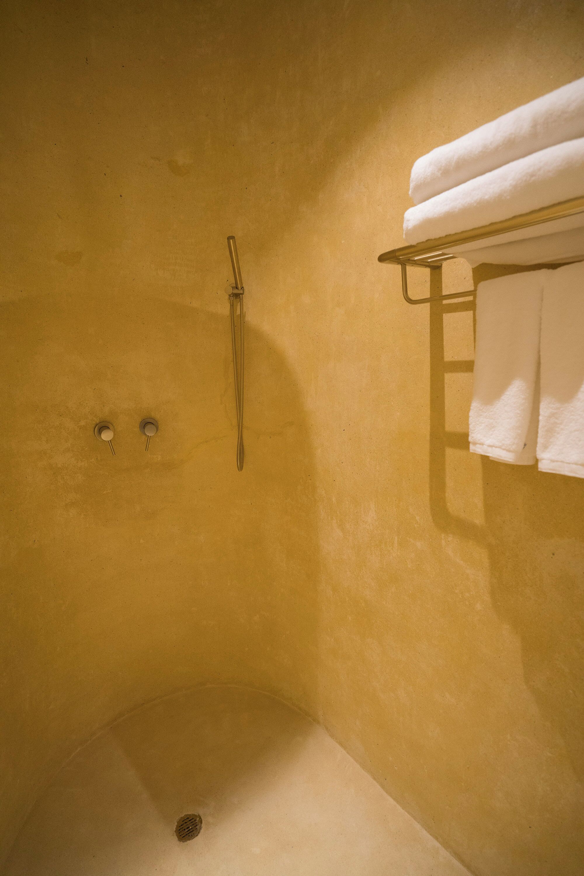 A bathroom with a bathtub, a towel rack with towels, and a showerhead.