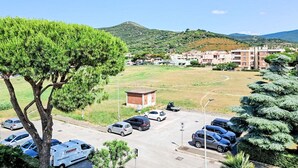 Zona residencial con edificios de apartamentos, un estacionamiento y un árbol grande al frente.