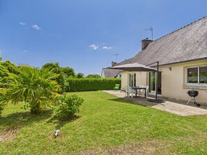 A house with a patio, a table with chairs, and a barbecue grill. - Single-storey house for 4 – garden and terrace (La Forêt-Fouesnant)