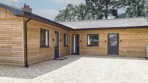 Eine Holzhütte mit Kiesweg und überdachter Terrasse.