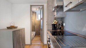A compact kitchen with a stainless steel sink, a coffee maker, and a toaster. - 'Coin Vert' Apartment with Mountain Views, Shared Garden and Wi-Fi (Gressan)