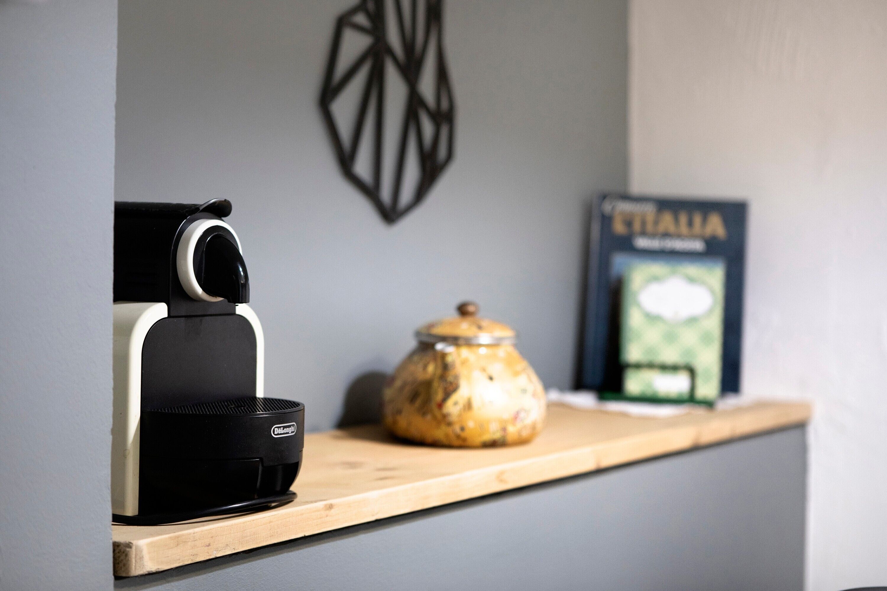A coffee machine, a decorative jar, and a book titled 'ITALIA' on a shelf.