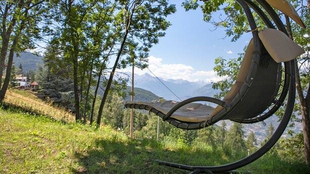 A hammock in a natural setting with trees and mountains in the background. - 'Coin Vert' Apartment with Mountain Views, Shared Garden and Wi-Fi (Gressan)