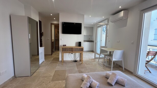 Una habitación de hotel moderna con cama, escritorio, televisión y balcón.