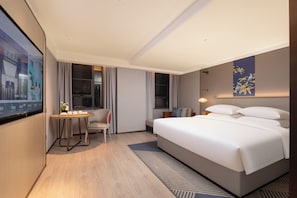 A modern hotel room with a large bed, a desk with a chair, a TV on the wall, and a window with curtains. - ECHENG Hotel, Jianghan Road Pedestrian Street, Wuhan River Beach (Wuhan)