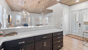 A spacious kitchen with a large island, dark cabinetry, and a wooden ceiling. - Reel McCoy, Seagrove Home with Hot Tub & Fire Pit (Santa Rosa Beach)