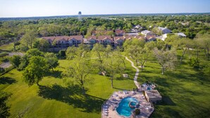 A residential area with multiple houses, a swimming pool, and a water tower in the background.