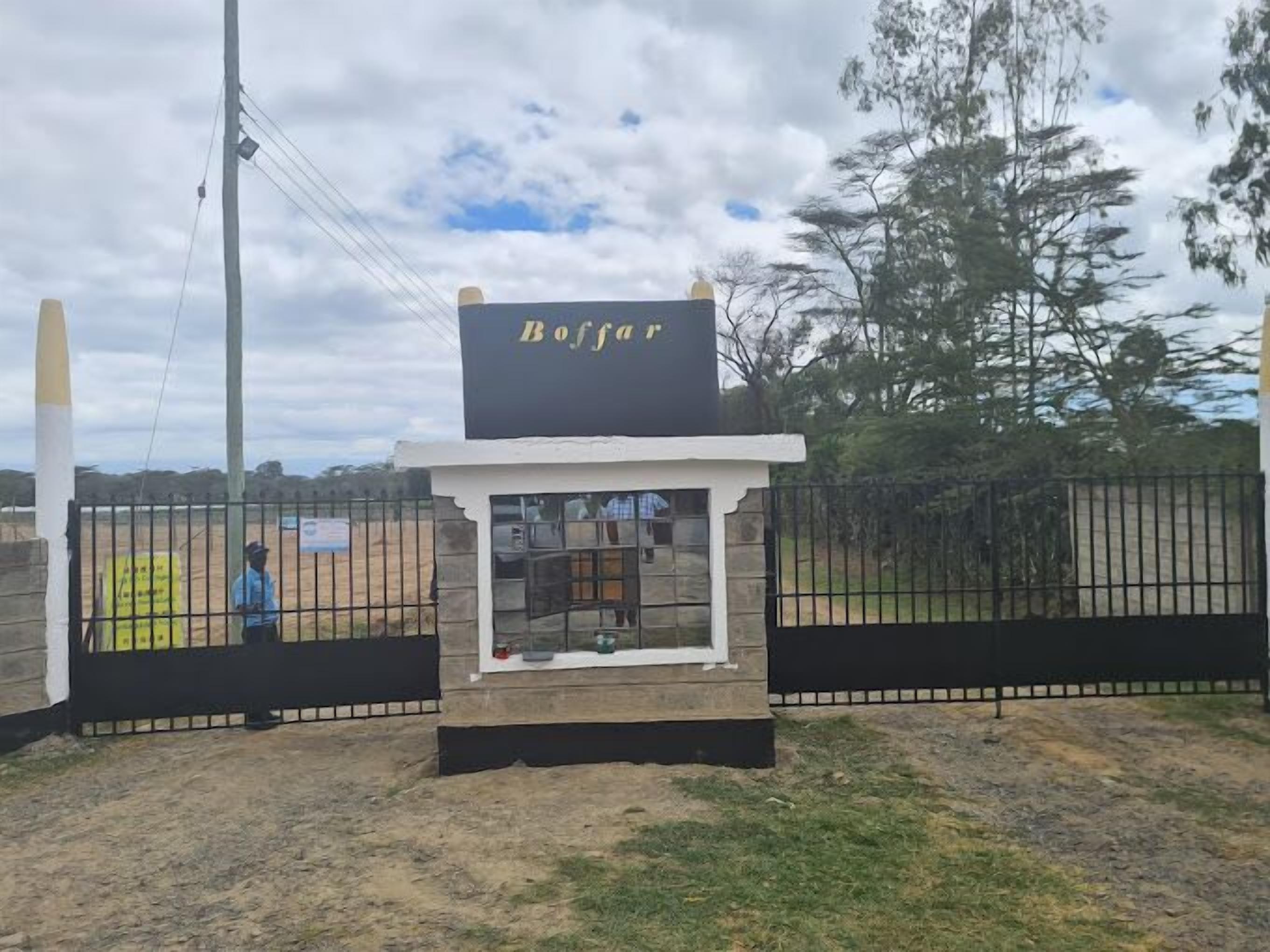 Una pequeña construcción con un cartel que dice "Buffar" frente a una zona cercada.