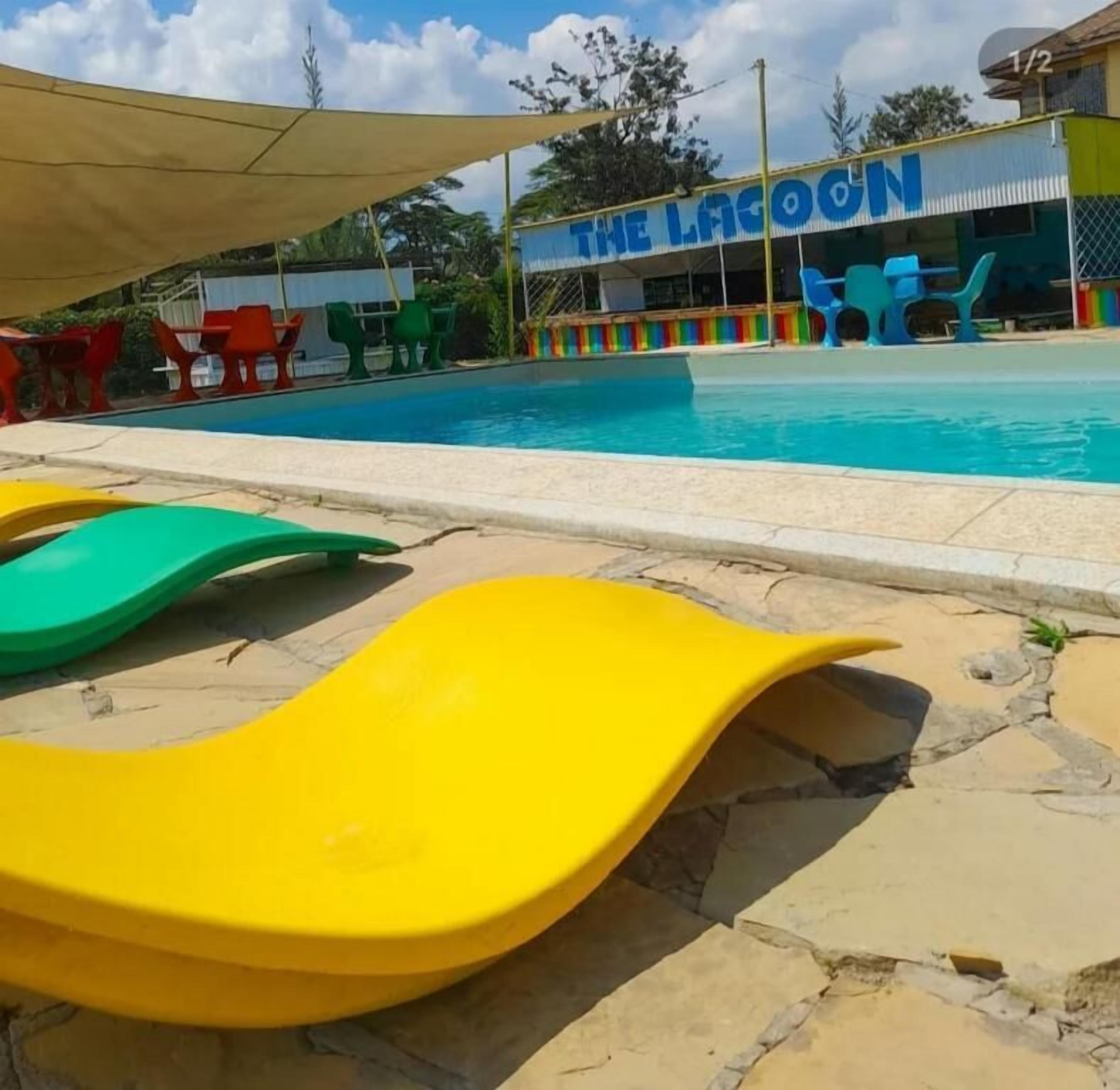 Piscina com escorregadores e um edifício com a inscrição 'THE LAGOON' ao fundo.