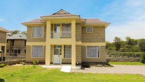 A two-story house with a central entrance, a balcony, and a small porch. - Lux Suites Boffar Residence Naivasha (Naivasha)