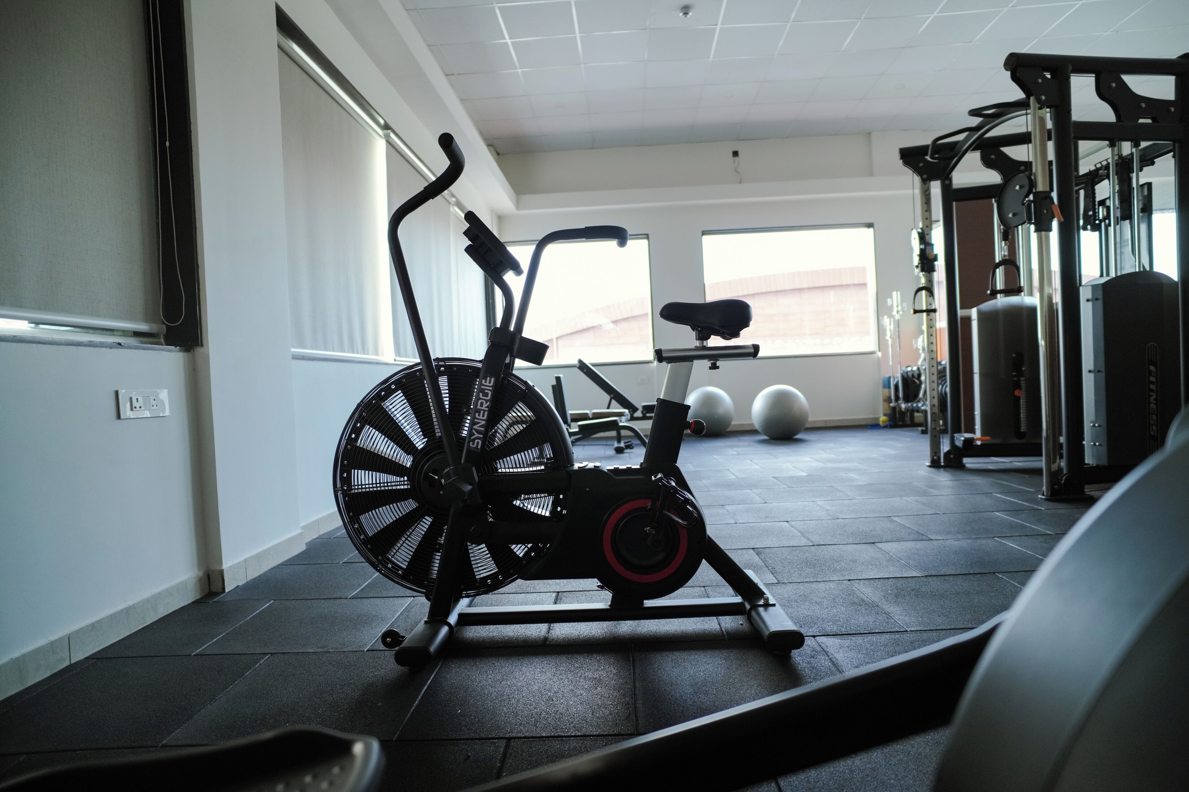 Un gimnasio con equipo de ejercicio, incluyendo una bicicleta estática y pesas.