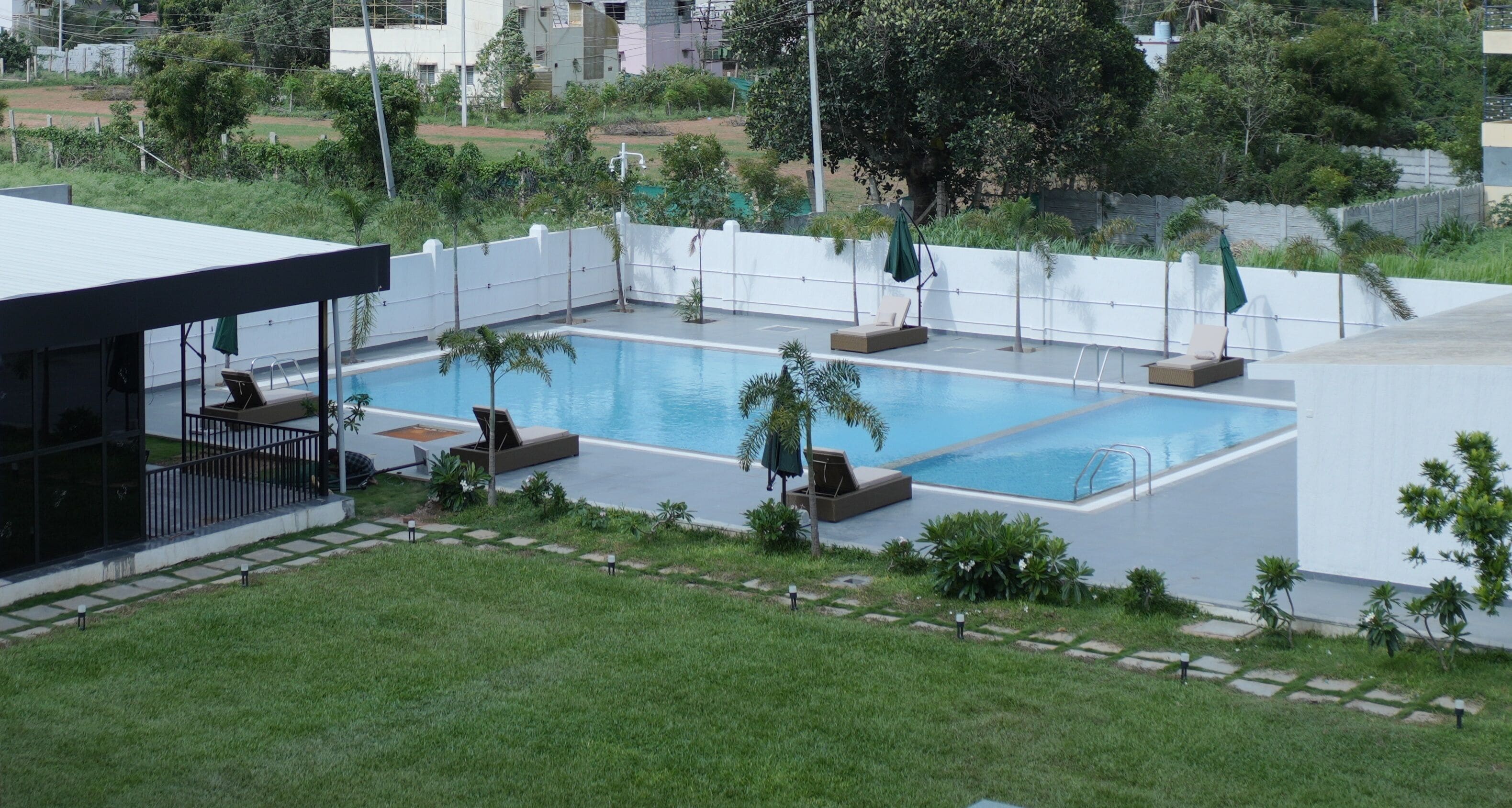 A rooftop pool with lounge chairs and a covered seating area.