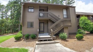 A two-story building with a front entrance, a staircase, and a small porch area. - Cradle of Condos ⛳️-  2 Bedroom Pinehurst Getaway (Pinehurst)