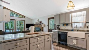A modern kitchen with grey cabinetry, a central island, and a built-in oven.